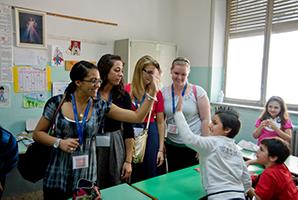 Students high five children.